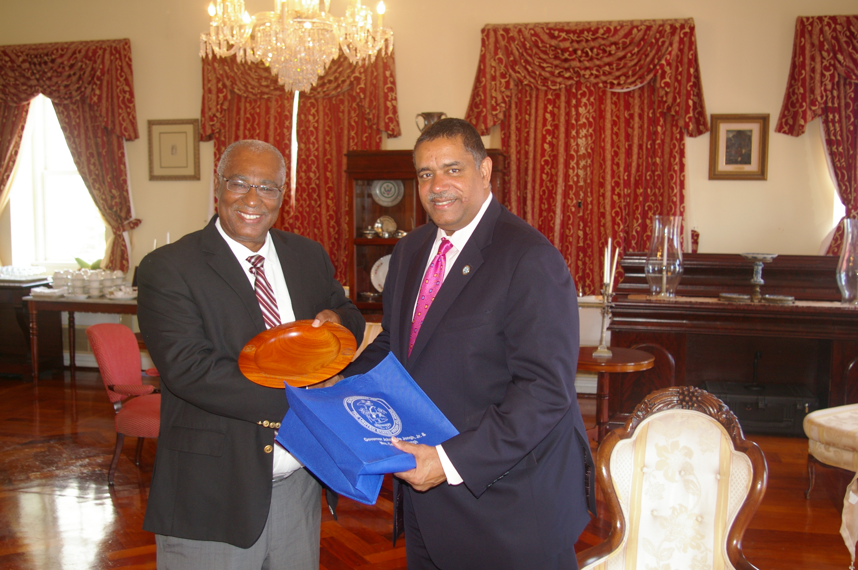 Premier, Hon. Joseph Parry receiving a gift of a local woodcarving from the Governor of the United States Virgin Islands (USVI), the Hon. John P. de Jongh